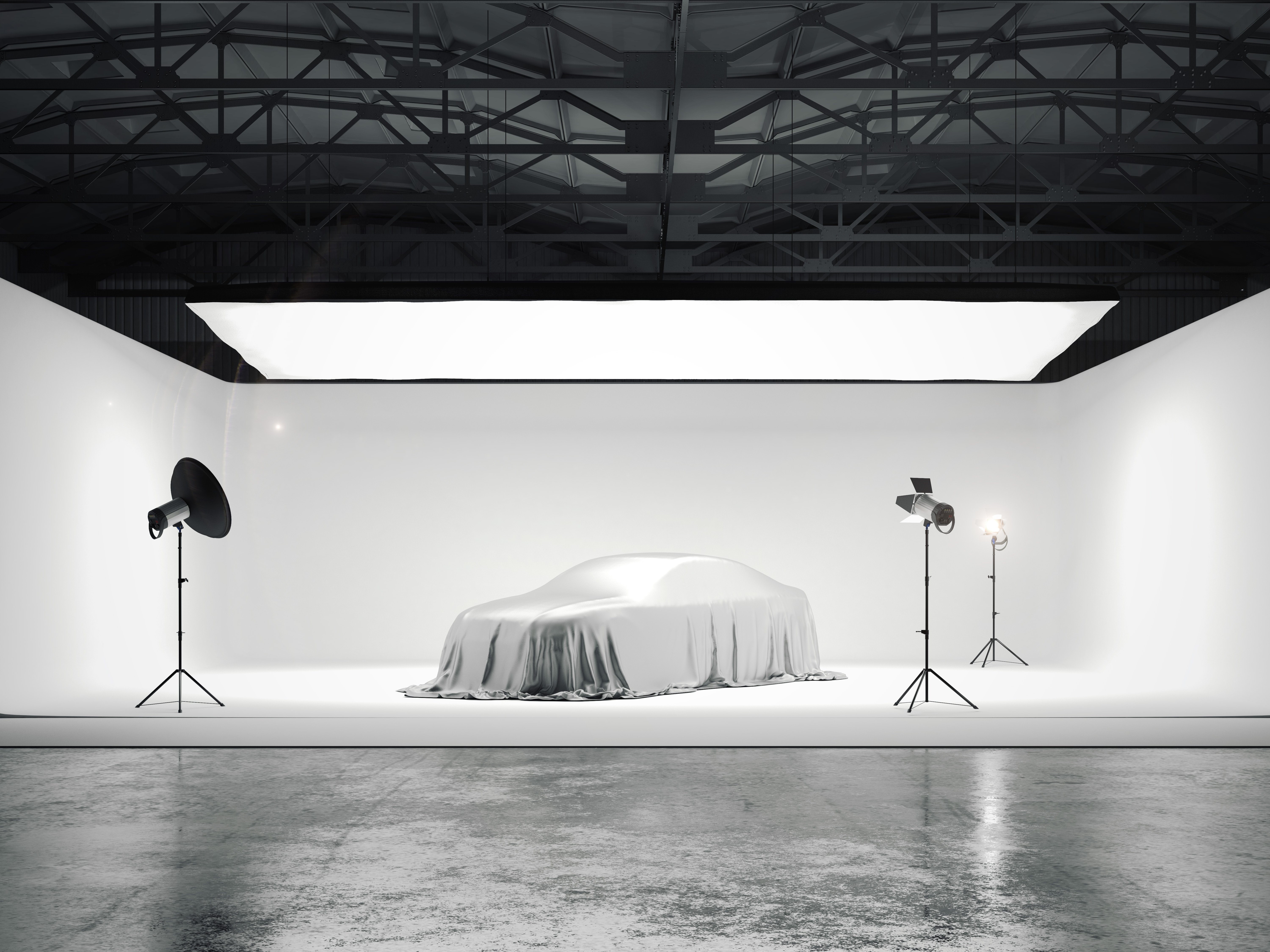 Grand studio photographique avec une voiture et plusieurs sources lumineuses
